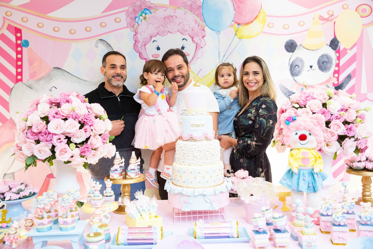 Festa infantil tema circo 2 anos menina rosa no colo do pai com a família mesa do bolo