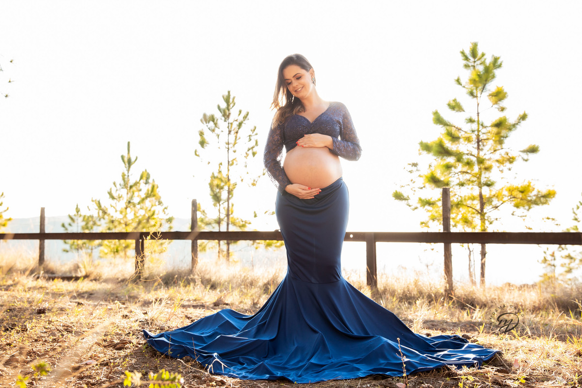Gestante mamãe esperando bebe que irá nascer segurando barriga vestido azul roupa saia longa sereia