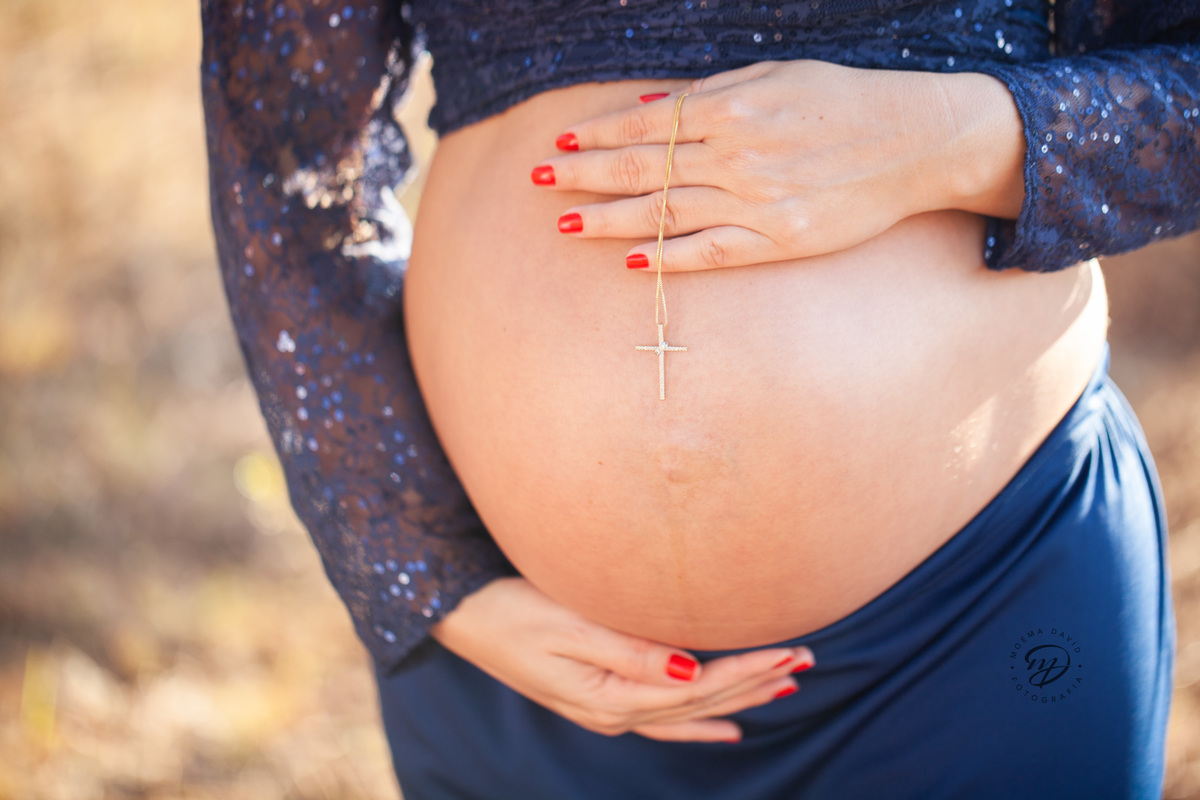 Gestante mamãe esperando bebe que irá nascer segurando barriga vestido azul roupa saia longa sereia 
