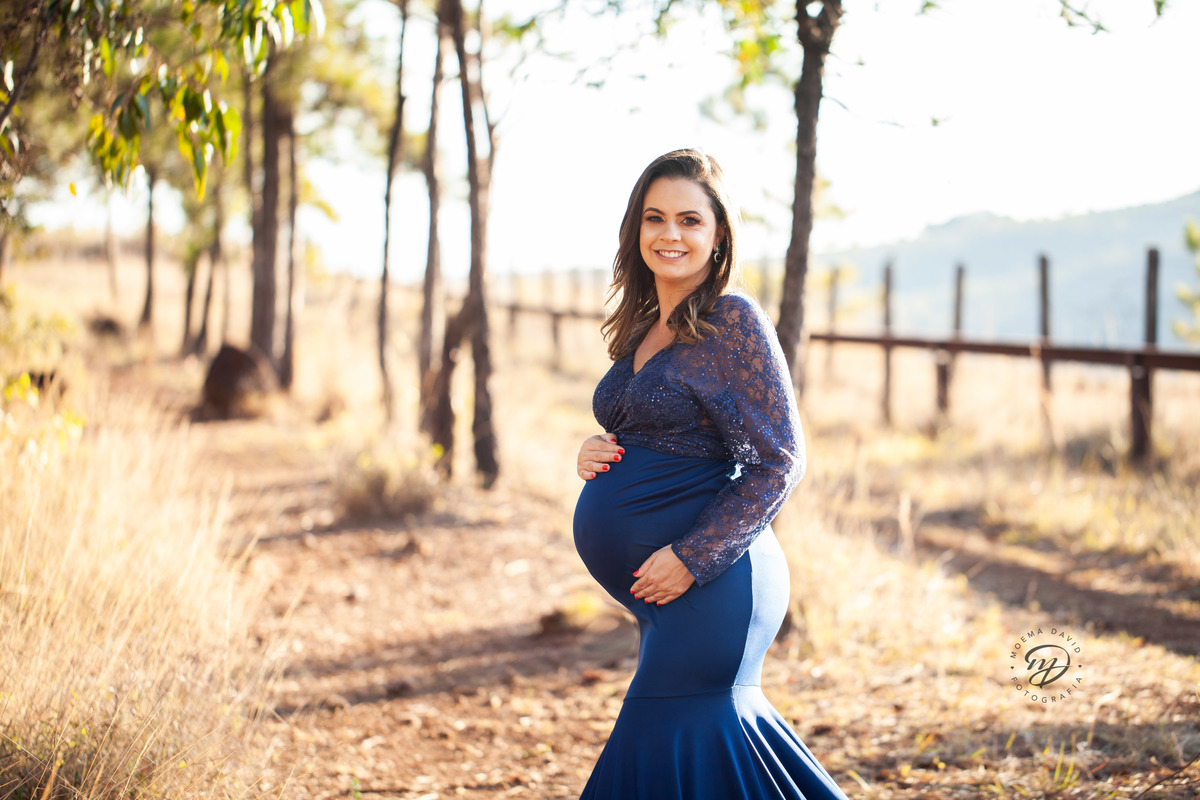 Gestante mamãe esperando bebe que irá nascer segurando barriga vestido azul roupa saia longa sereia