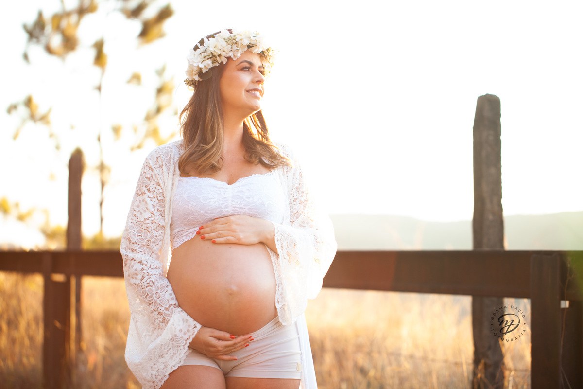 Gestante mamãe esperando bebe que irá nascer segurando barriga vestido branco roupa saia longa  pinheiros sereia coroa de flor