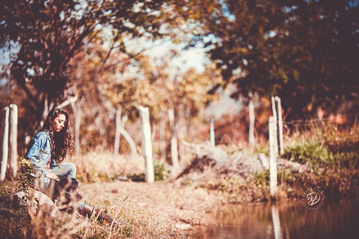 Debutante 15 anos country chapéu no ar jaqueta fifteen botas  mao no cabelo lago