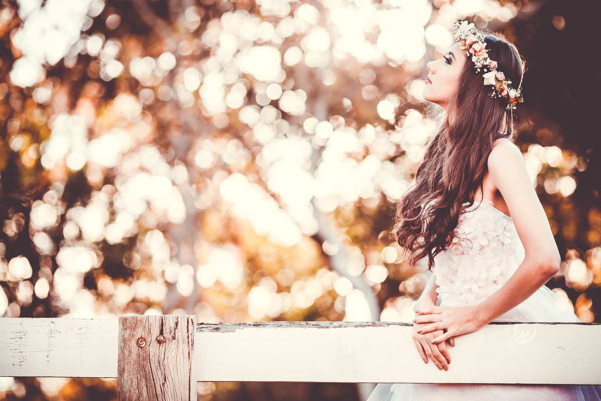 Debutante 15 anos natureza ar livre coroa de flores vestido rosa floral galhos luz natural vento no rosto