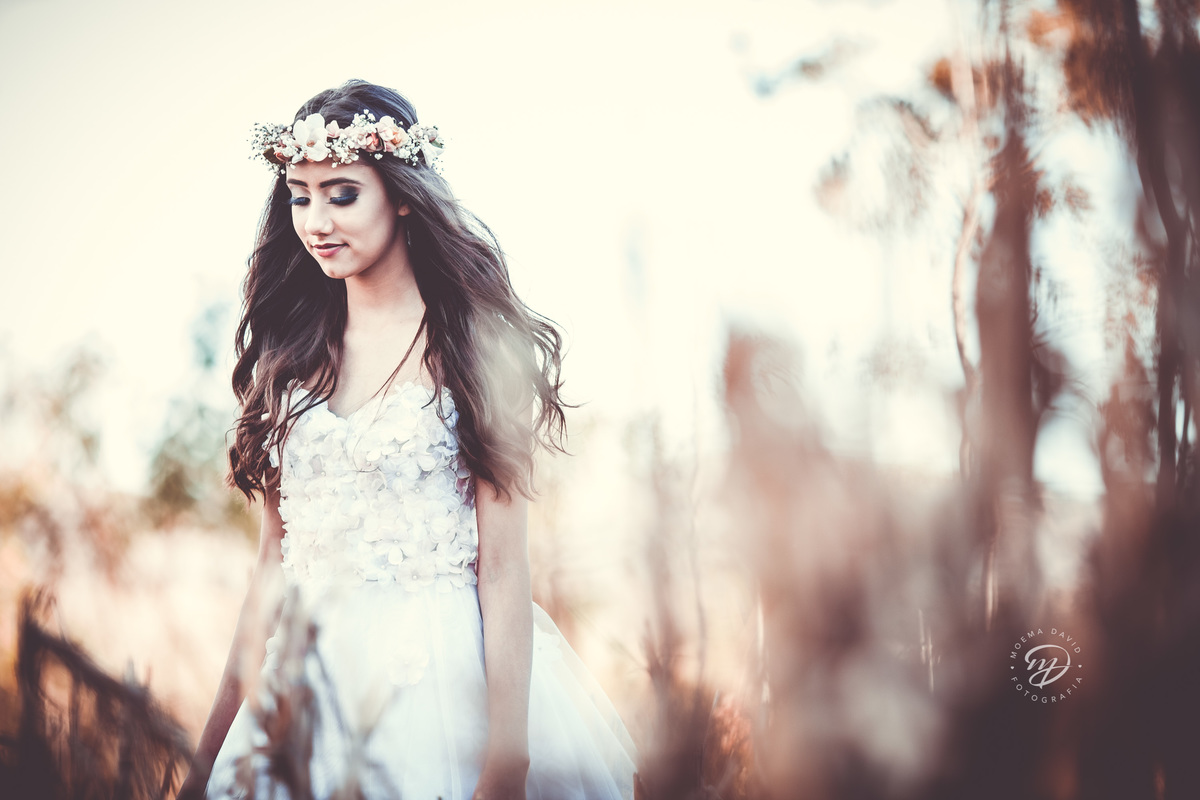 Debutante 15 anos natureza ar livre coroa de flores vestido rosa floral galhos luz natural floresta