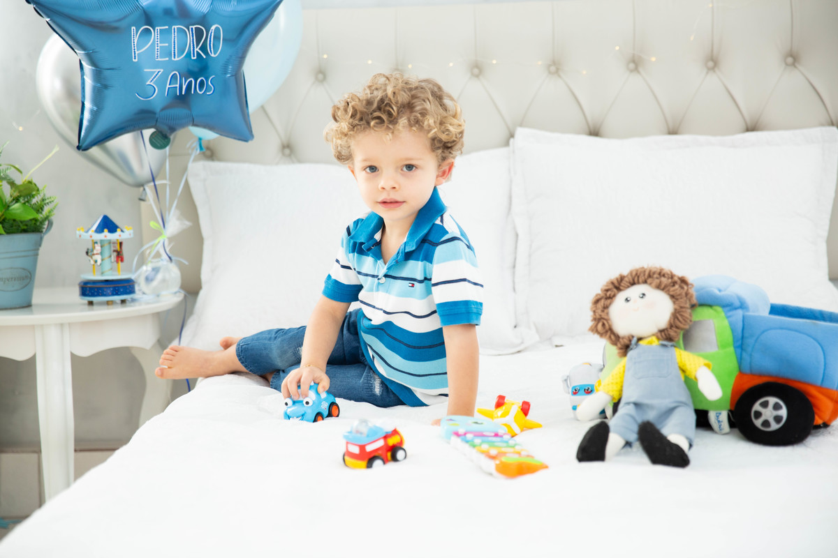 Menino lindo olhos azuis brinquedos carrinhos balões