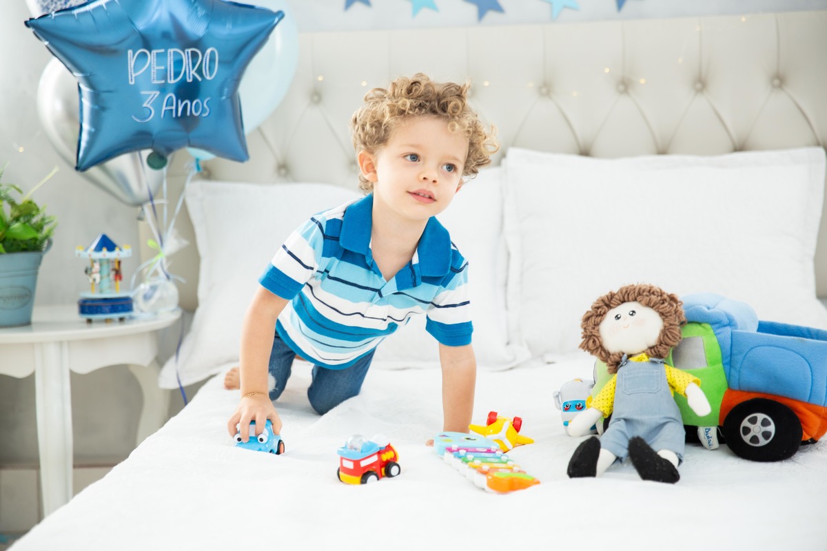 Menino lindo olhos azuis brinquedos carrinhos balões boneco