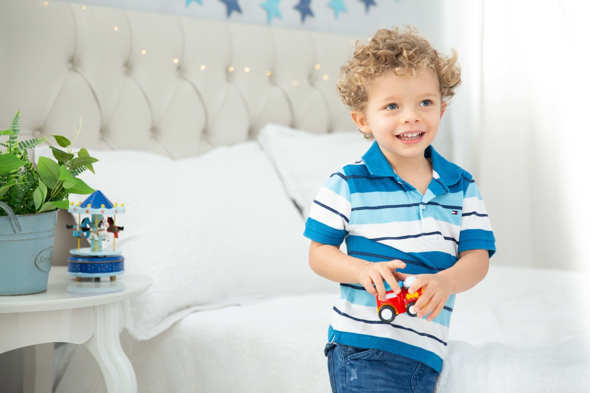 Menino lindo olhos azuis brinquedos carrinhos balões carrossel