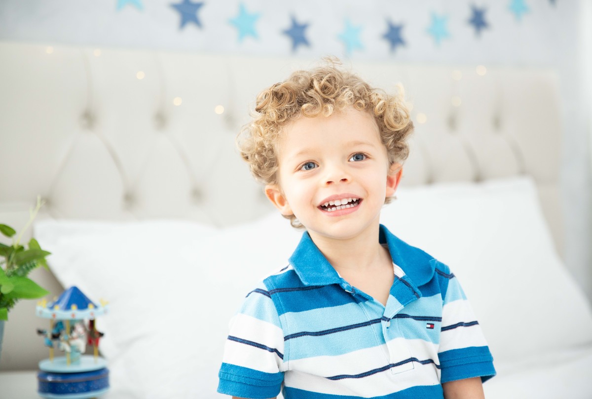 Menino lindo olhos azuis brinquedos carrinhos balões alegria
