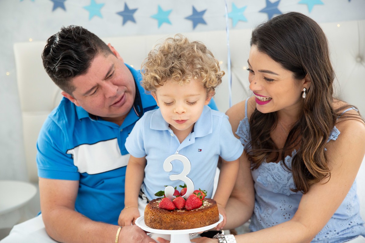 Menino lindo olhos azuis brinquedos carrinhos balões cama trem carrossel céu estrelas colo papai mamae soprando velinhas