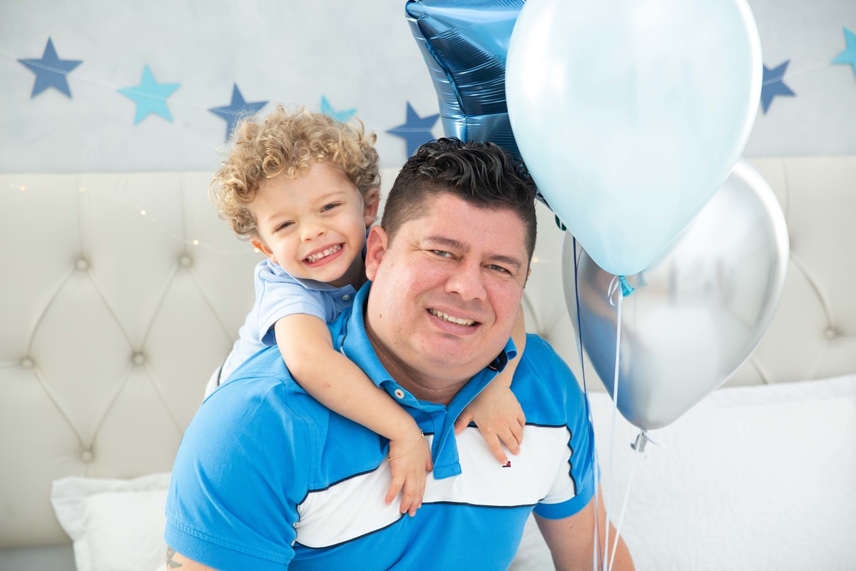 Menino lindo olhos azuis brinquedos carrinhos balões cama trem carrossel céu estrelas colo papai mamãe soprando velinhas morangos comer saudável bolo banana papai abraço