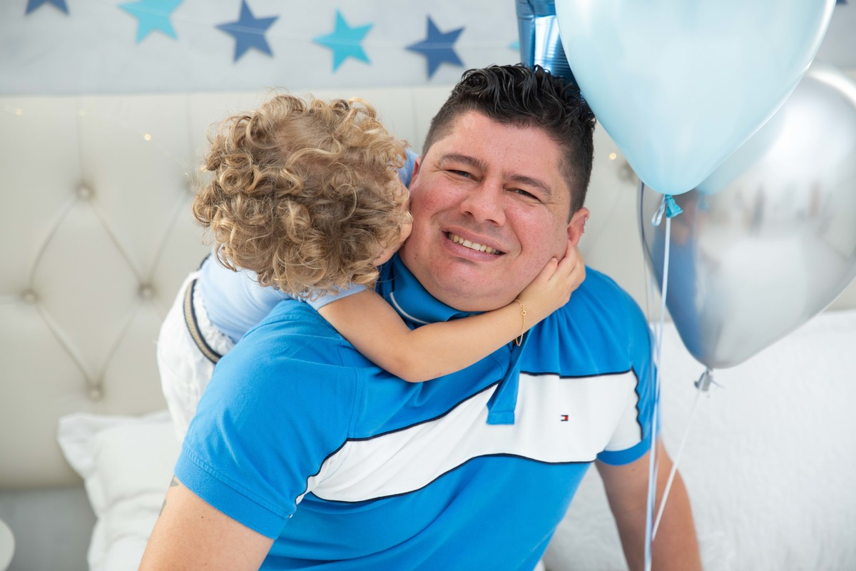 Menino lindo olhos azuis brinquedos carrinhos balões cama trem carrossel céu estrelas colo papai mamãe soprando velinhas morangos comer saudável bolo banana papai abraço