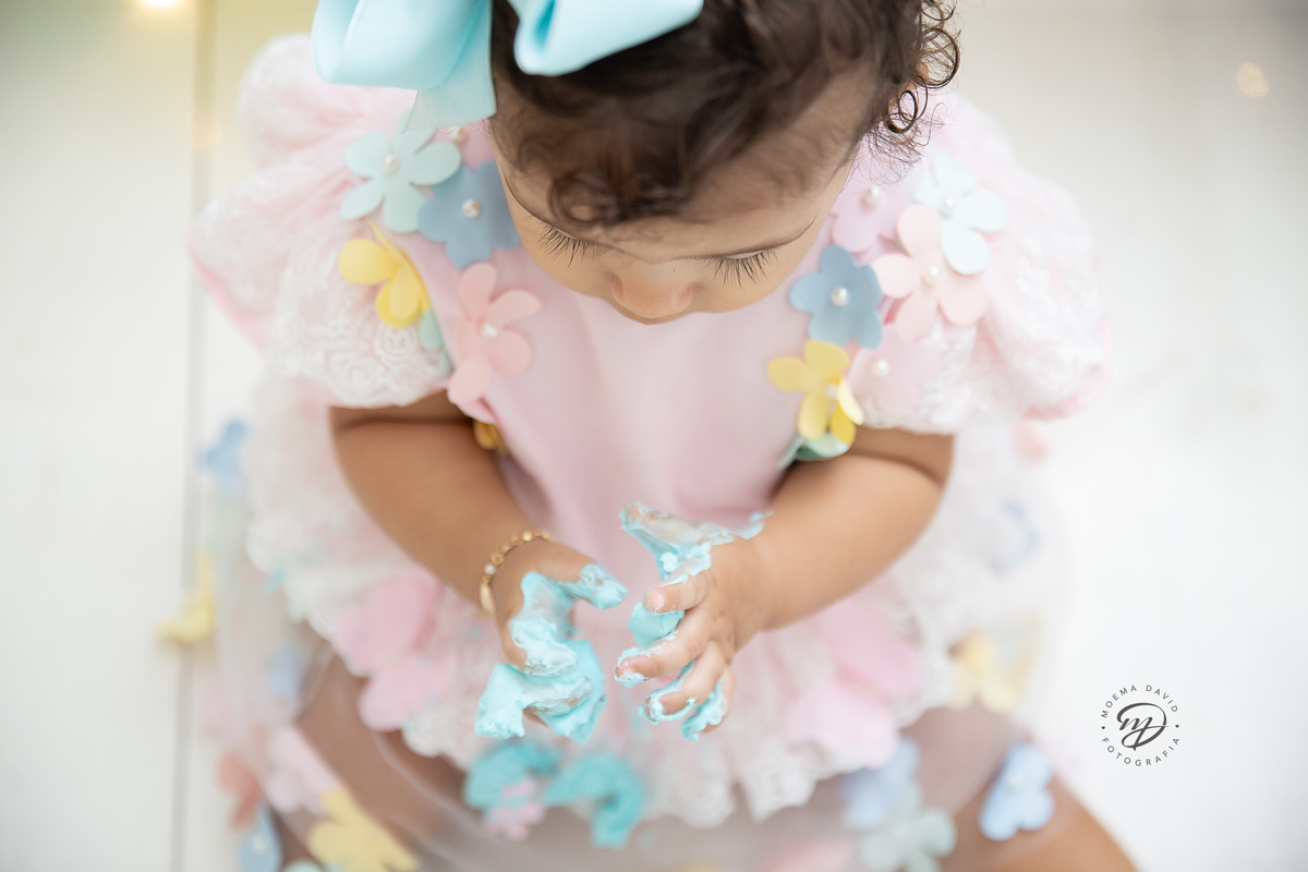 Ensaio Smash the cake - Manu está concentrada com esse chantininho em suas mãozinhas!