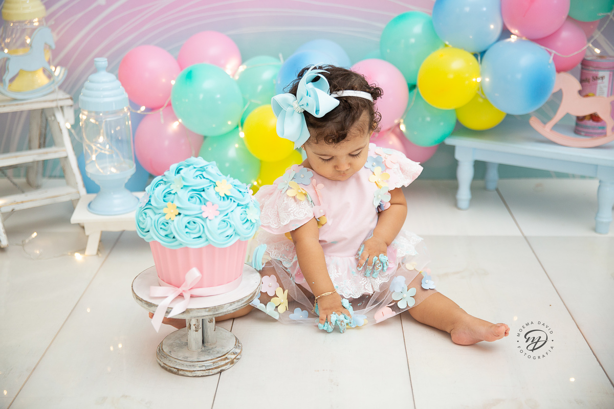 Ensaio Smash the cake - Manu está concentrada com esse chantininho em suas mãozinhas e desenha no chão!