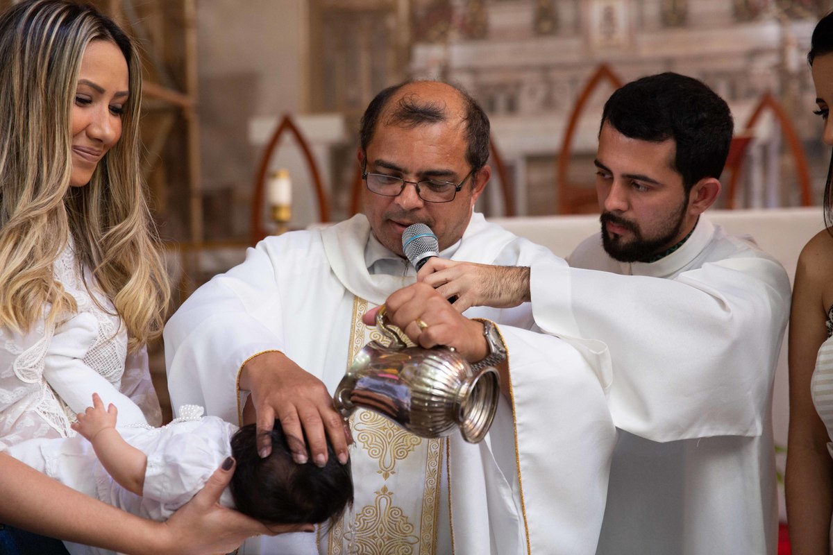 Batizado. Água sendo derramada na cabecinha da criança.