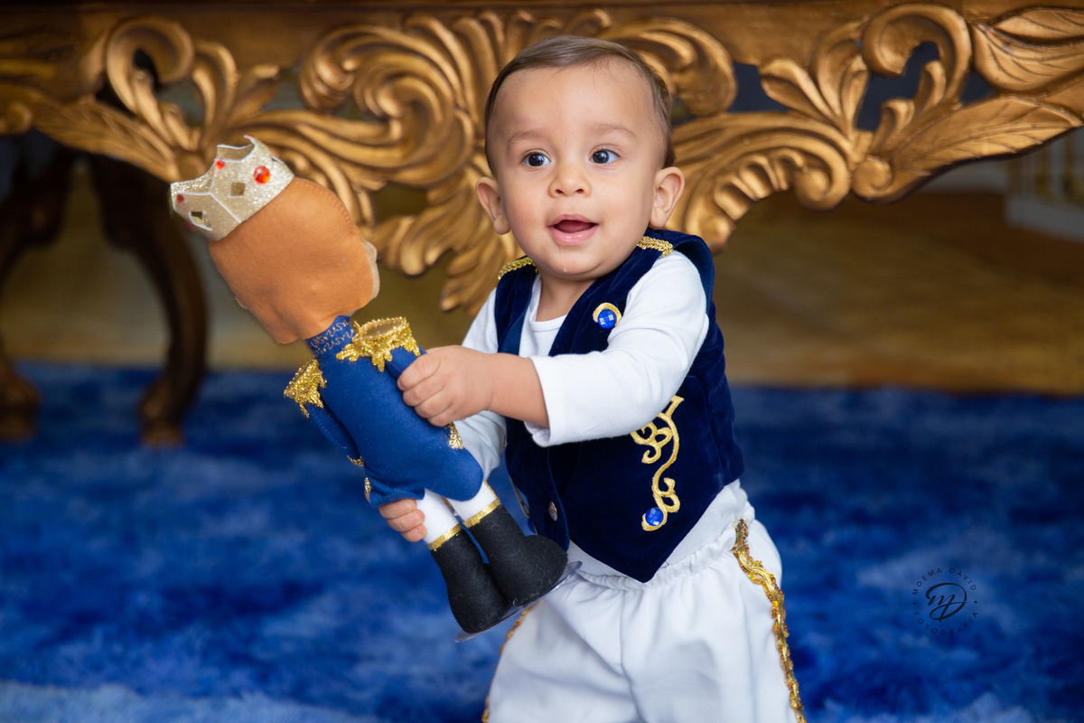 Príncipe Henrique em pé correndo em sua festa com o presente lindo que ganhou da sua tia