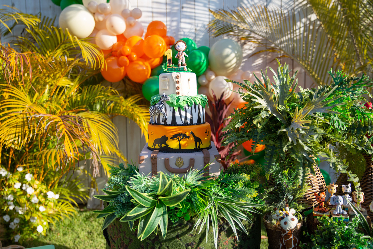 Aniversário Safari Baby: bolo quatro andares. Topo de bolo com vela de número 1 e explorador.
