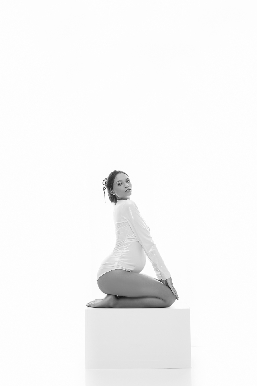 Ensaio Gestante grávida de joelhos sobre banco de MDF