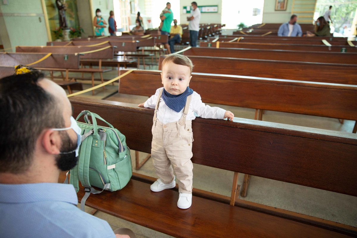 Menino no banco da igreja momentos antes do batizado