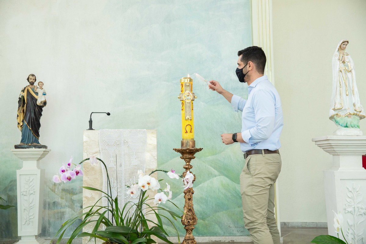 padrinho acendendo vela batismo