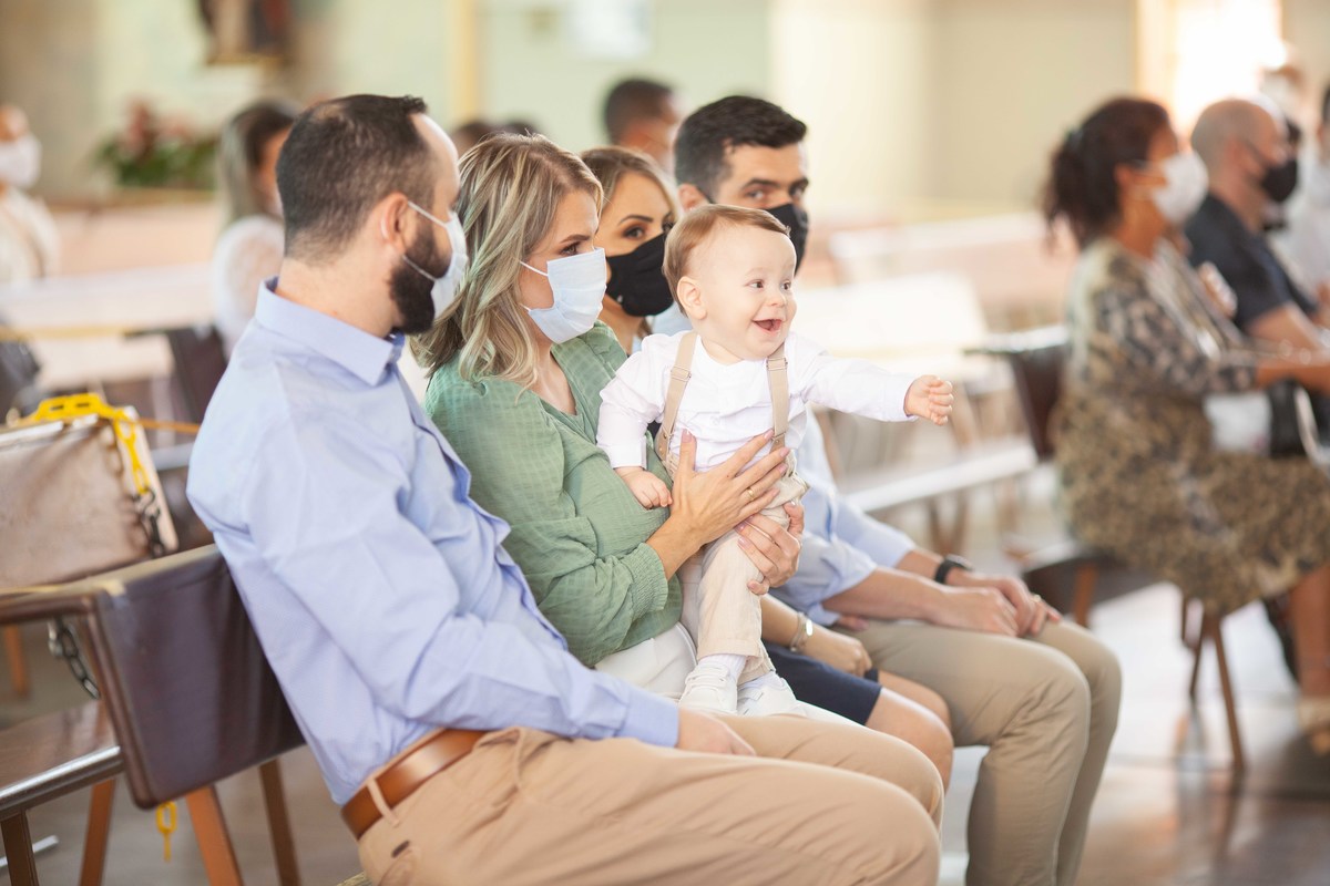 Menino colo mae sorrindo barizado