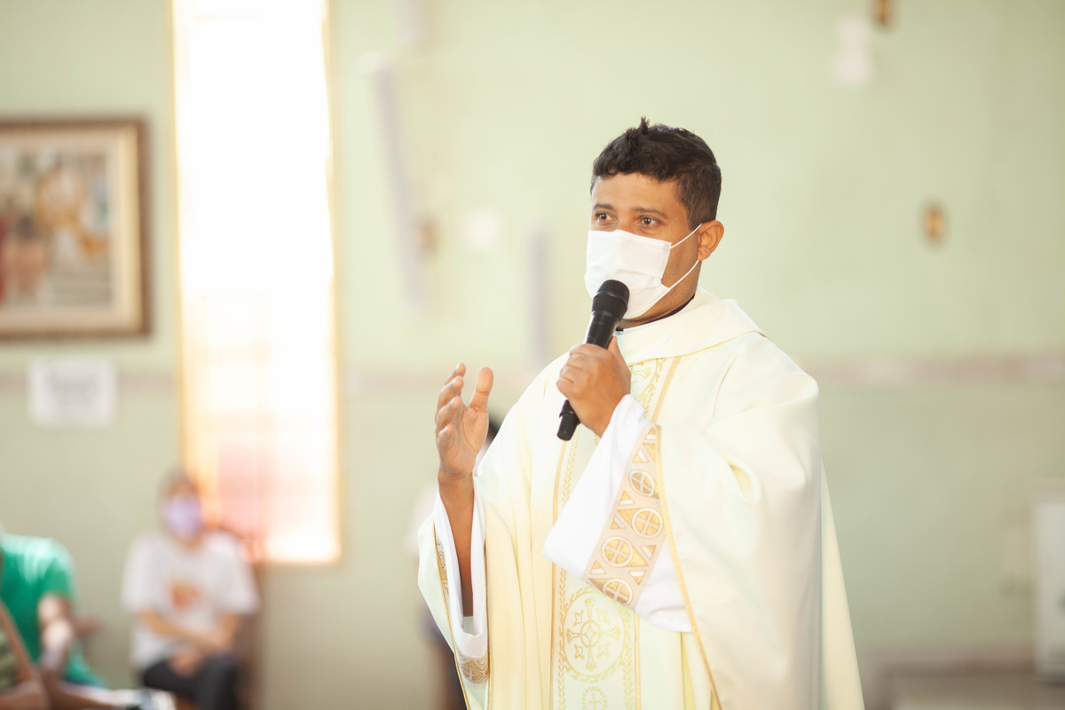 PAdre pregando homilia no batizado