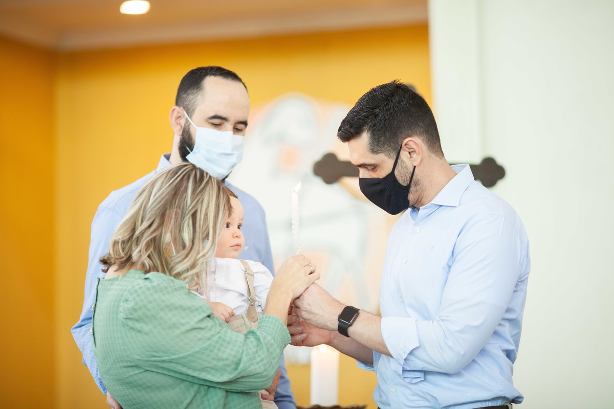 padrinho e menino tocando vela batismo