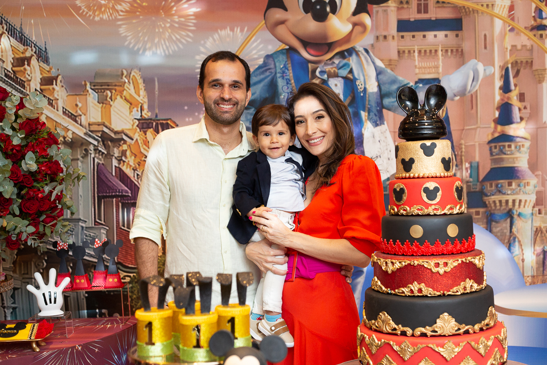 Mãe e pai com filho no colo- festa de aniversário tema da Disney