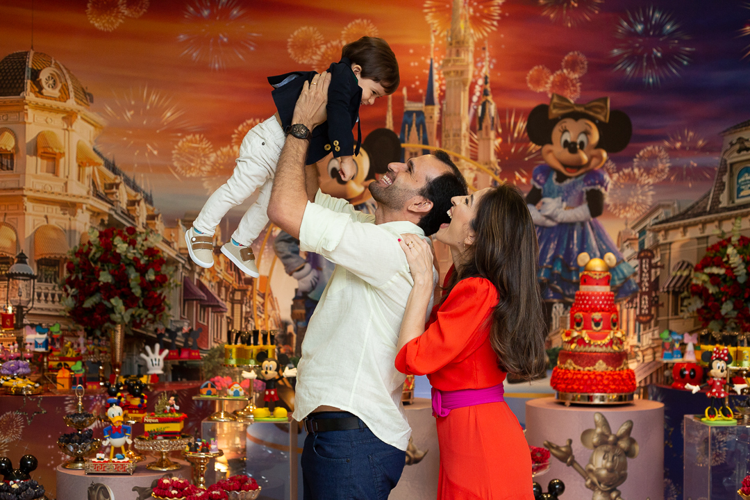 Pai segurando seu filho no alto - festa de aniversário tema da Disney