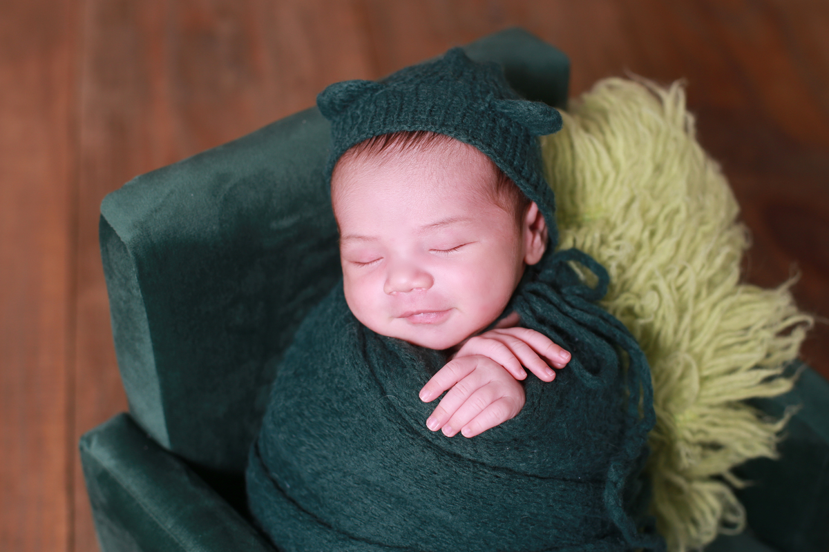 Ensaio de newborn com o bebê sorrindo.