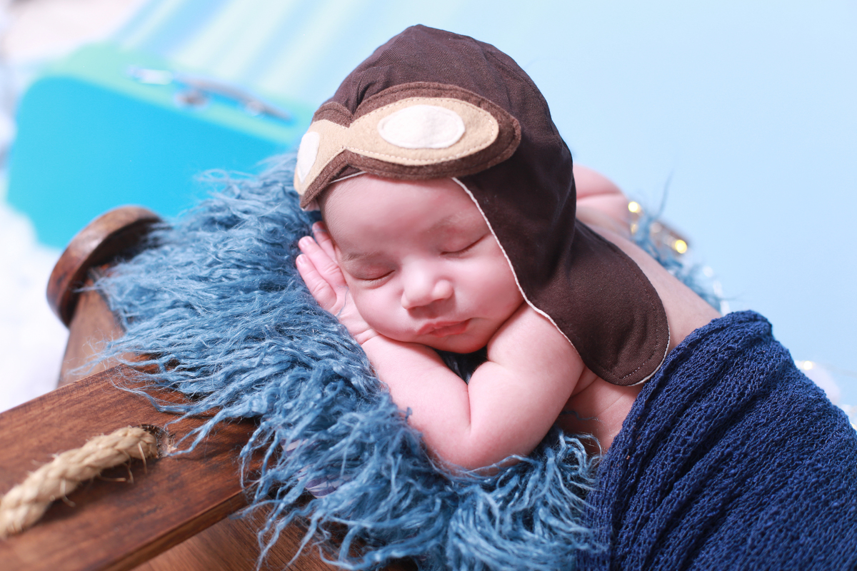 Bebê com roupinha de aviador.