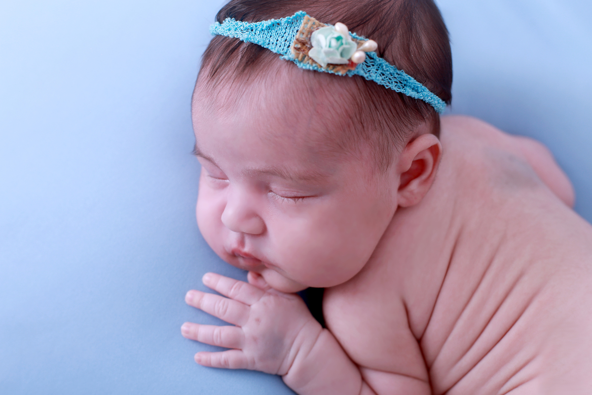 Ensaio newborn com bebê recém-nascido em estúdio.