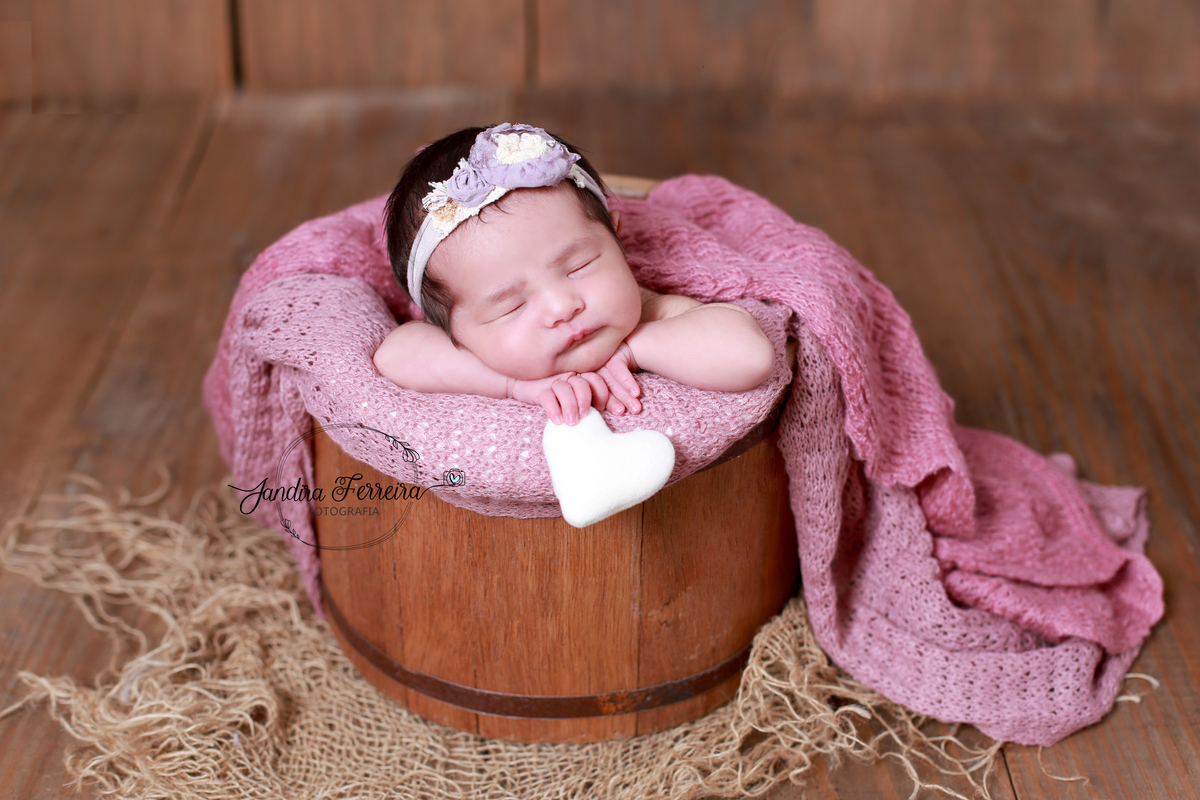 Fotografia newborn em família japonesa – pais sorrindo com o bebê recém-nascido no colo, em cenário neutro e acolhedor