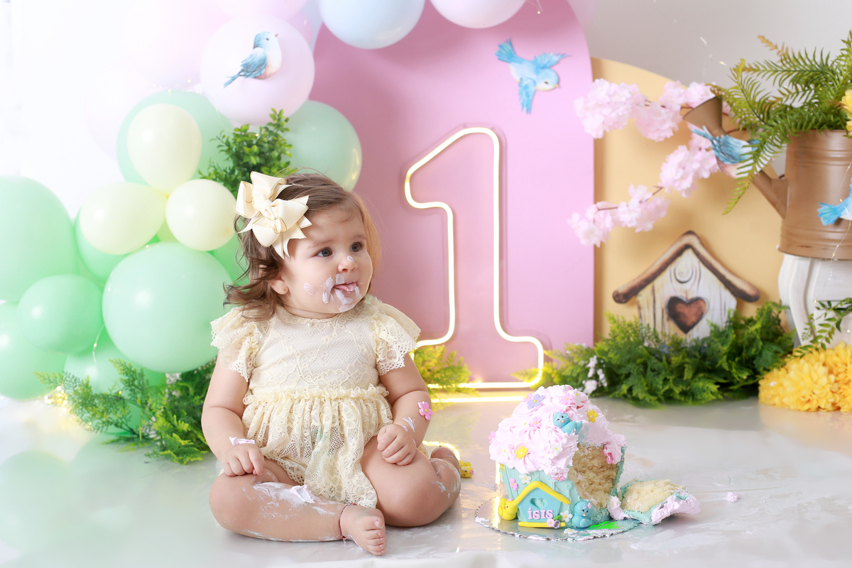 O bebê se divertindo enquanto o bolo vira brincadeira no Jardim Encantado