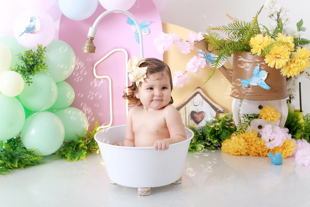 Final do ensaio: bebê todo lambuzado, rindo entre as flores — registro perfeito do Smash the Cake.