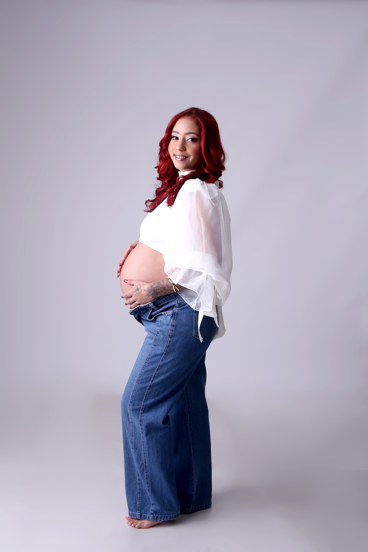 gestante de calça jeans e top bufante
