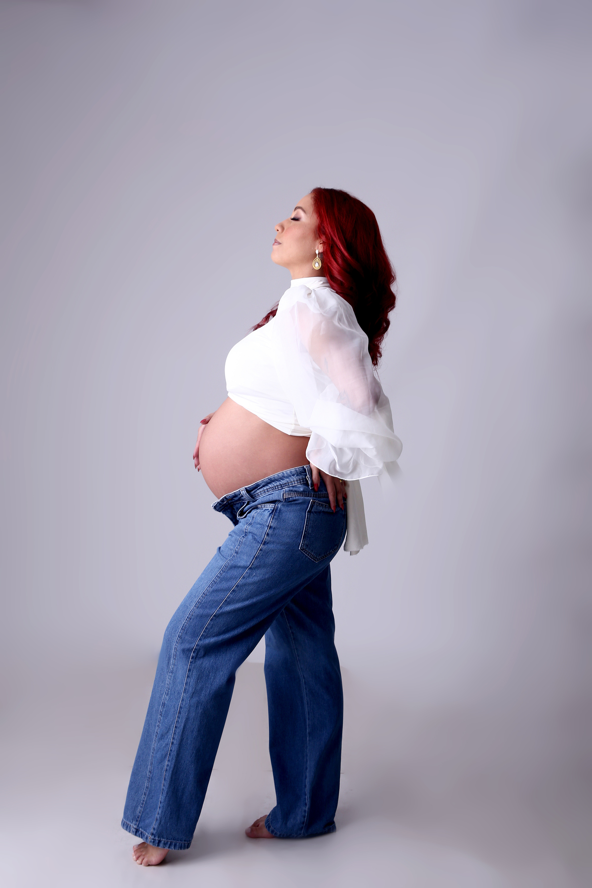 gestante de calça jeans e top bufante