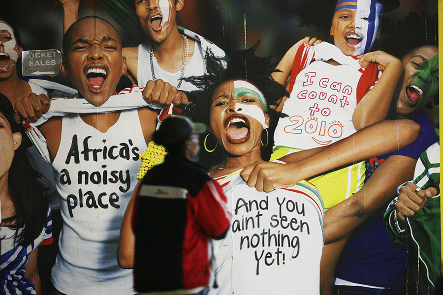 Mulher africana observa painel de torcedores