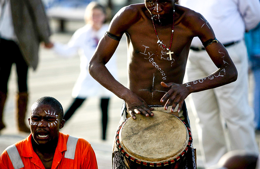 Africano com corpo pintado toca tambor na rua durante Copa na África do Sul em 2o10