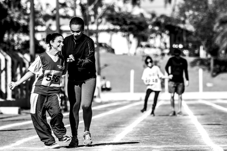Atletas correm com acompanhantes nas olimpíadas das Apaes