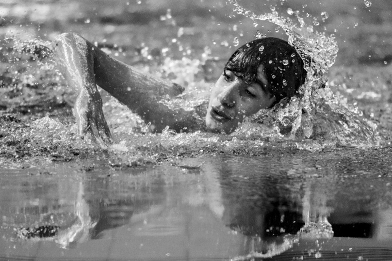 Homem competindo na piscina  durante olimpíadas das Apaes