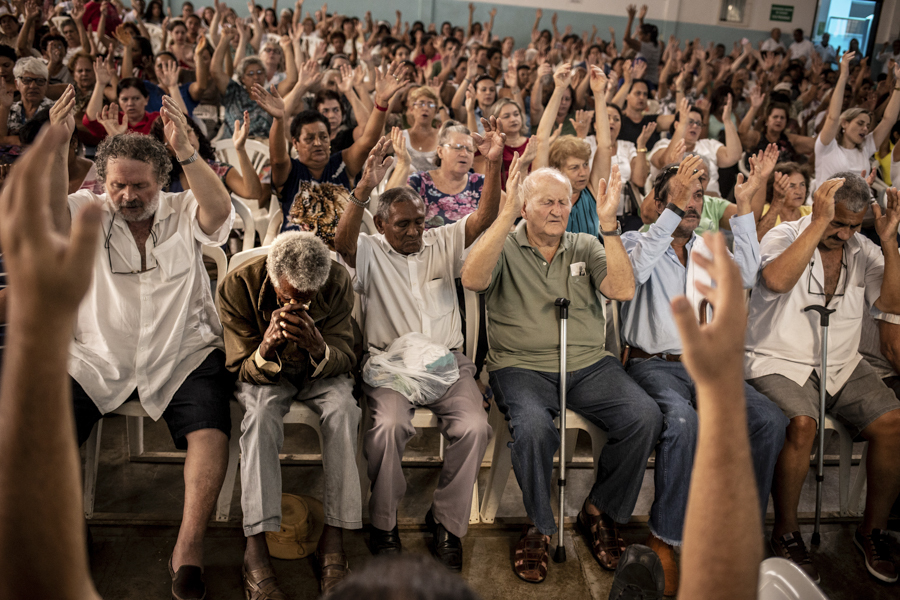 Pessoas cantam músicas do centro espírita e se emocionam