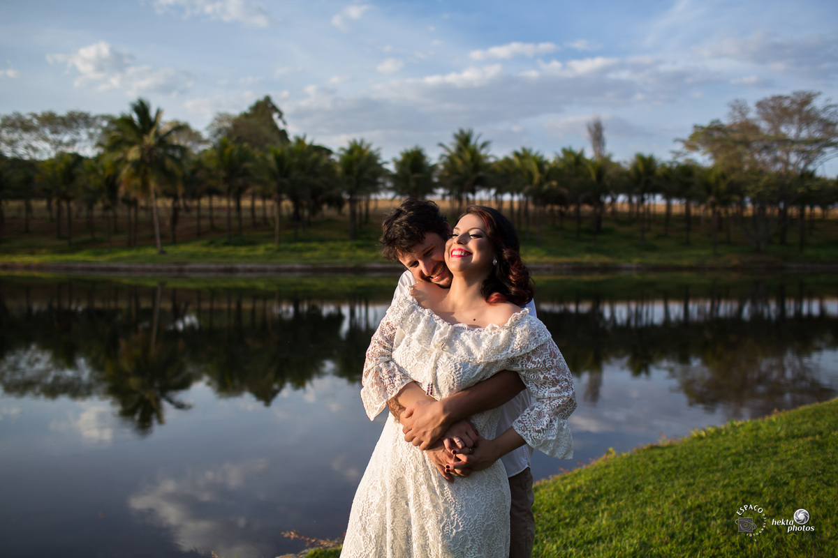 noiva e noivo se abraçando na beira do lago