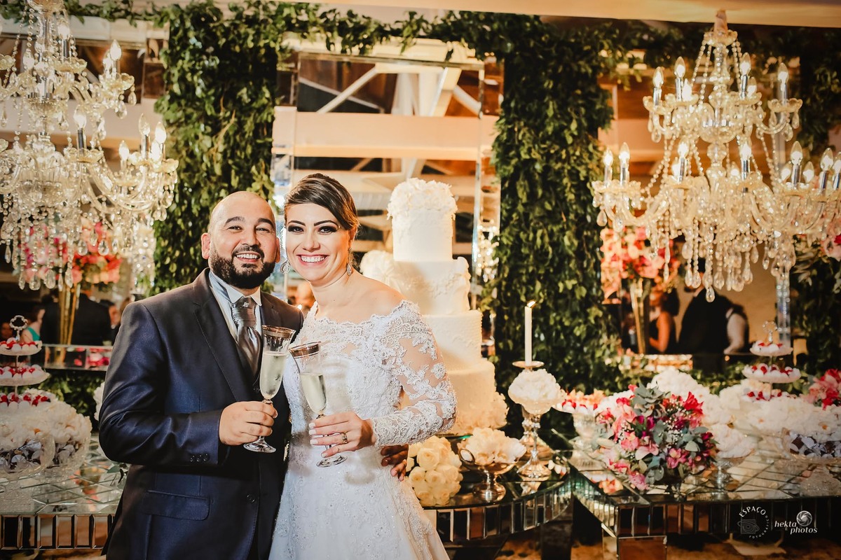 MOMENTO DO BRINDE DO CASAL NA FRENTE DA MESA DE BOLO CLUBE ALPHAVILLE GOIANIA FOTOGRAFIA DE CASAMENTO FOTOGRAFO DE CASAMENTO