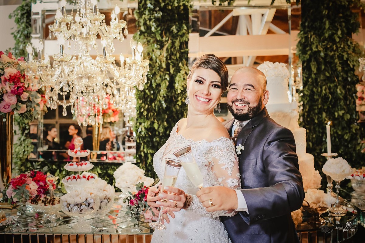 MOMENTO DO BRINDE DO CASAL NA FRENTE DA MESA DE BOLO CLUBE ALPHAVILLE GOIANIA FOTOGRAFIA DE CASAMENTO FOTOGRAFO DE CASAMENTO