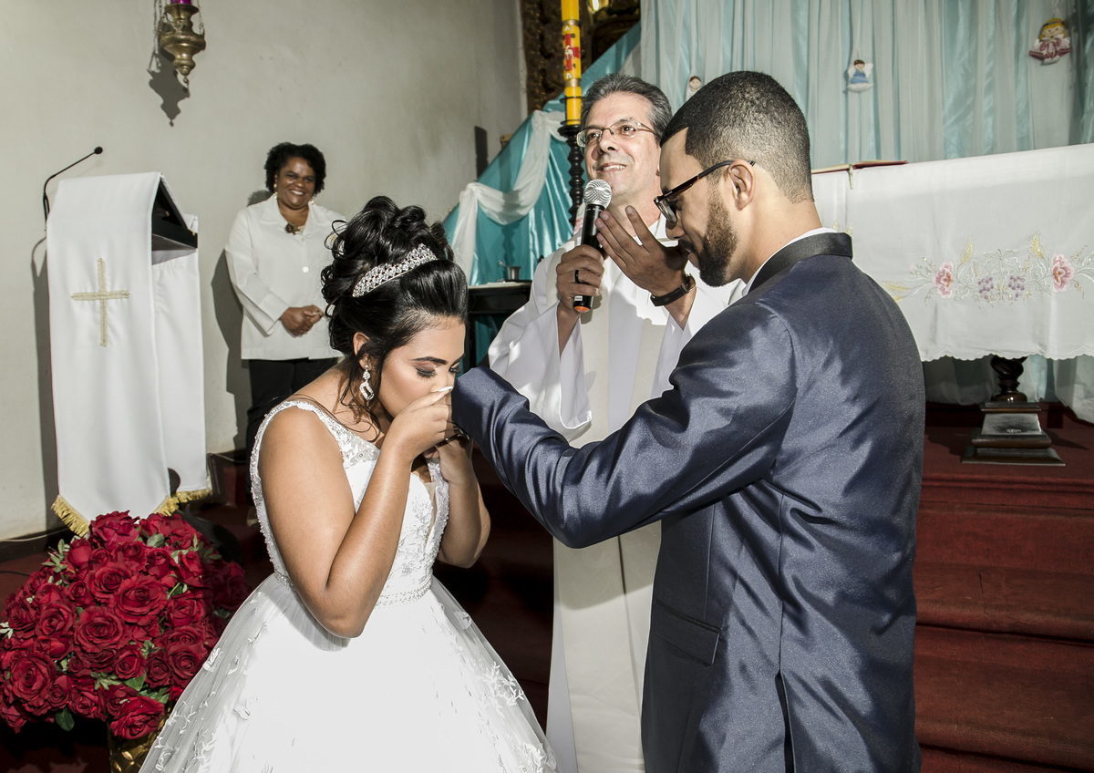 Noiva Beijando a mão do noivo na igreja. Casamento de Thaynara e Jonathan, Passagem de Mariana, Mariana MG
