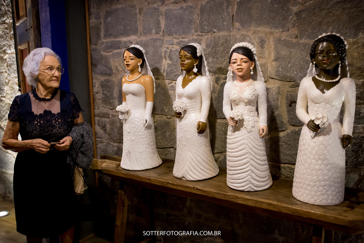 senhora observa imagens de quatro noivas e relembra seu casamento registro feito pela sotter fotografia fotografos de casamento em trancoso e arraial 