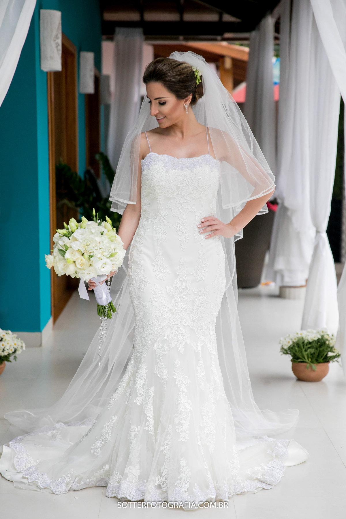 noiva segurando o buque com a mao na cintura 