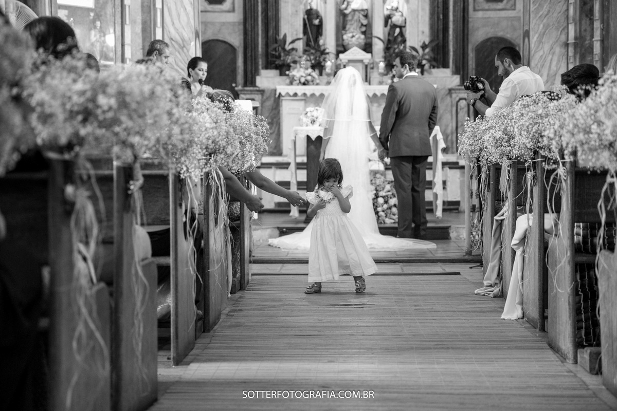 criança correndo no corredor da igreja enquanto acontece a cerimônia 