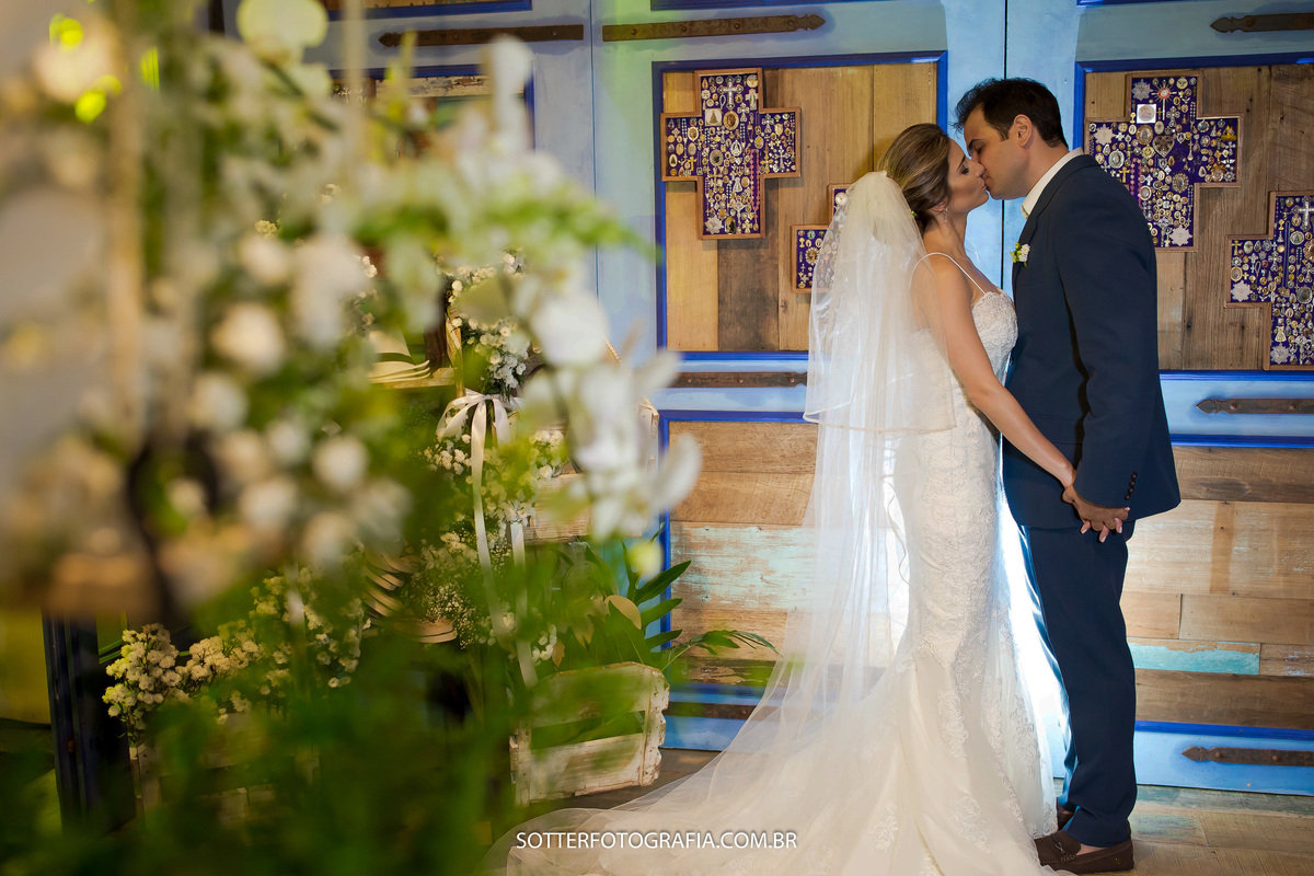 moldura azul com cruzes e o beijo dos noivos