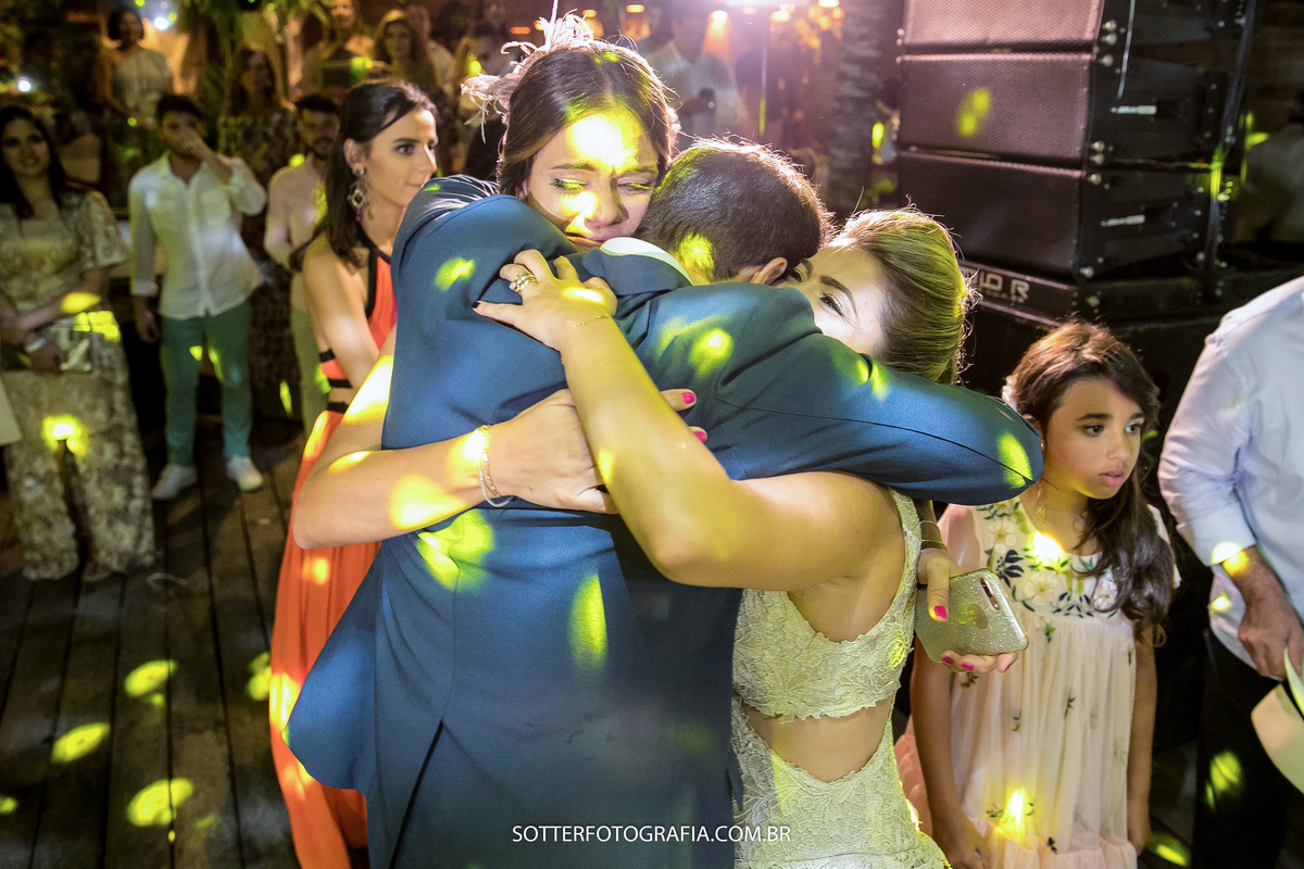 irmãs do noivo abraçando ele e chorando de felicidade